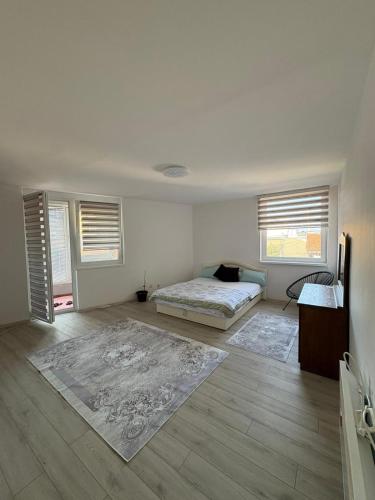 a bedroom with a bed and two windows at Apartment Lamele Bugojno in Bugojno