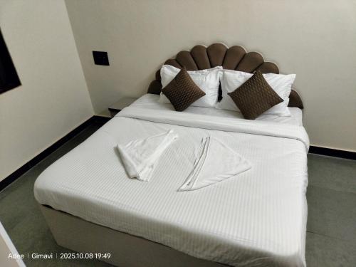 een bed met witte lakens en servetten erop bij Sukhad Home Stay in Gimvi