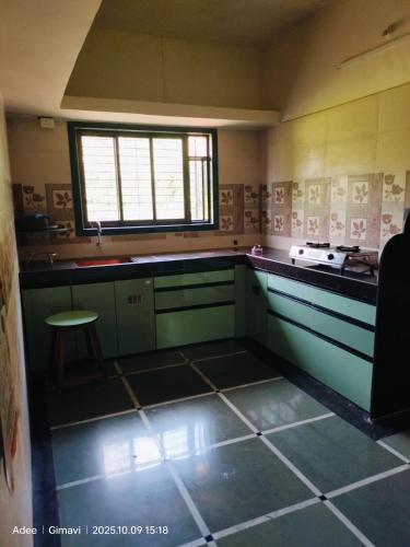 a kitchen with green cabinets and a window at Sukhad Home Stay in Gimvi