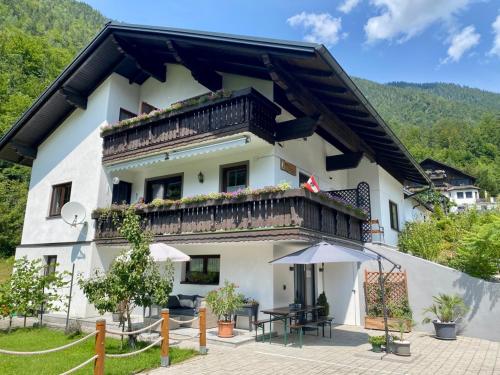 Großes weißes Gebäude mit Balkon in der Unterkunft Haus Salzkristall in Obertraun