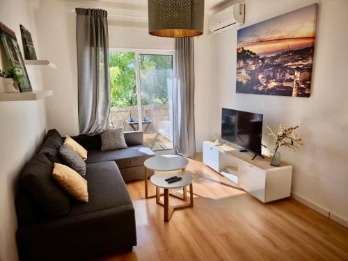 a living room with a couch and a tv at Casa Bem-Vindo in Olhão