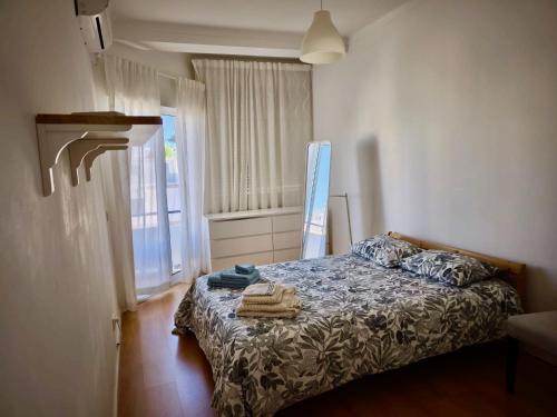 a bedroom with a bed with towels on it at Casa Bem-Vindo in Olhão