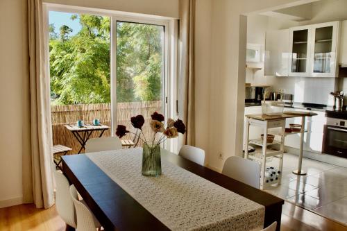 a kitchen with a table with a vase of flowers on it at Casa Bem-Vindo in Olhão