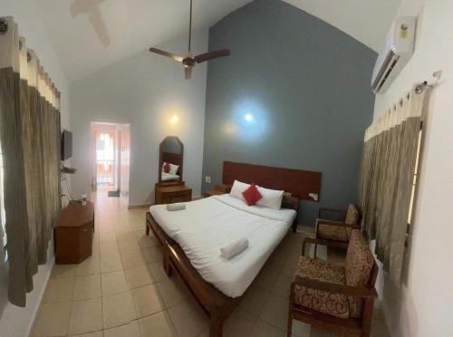 une chambre avec un lit et une chaise dedans dans l'établissement Kawari Resort, à Gokarna