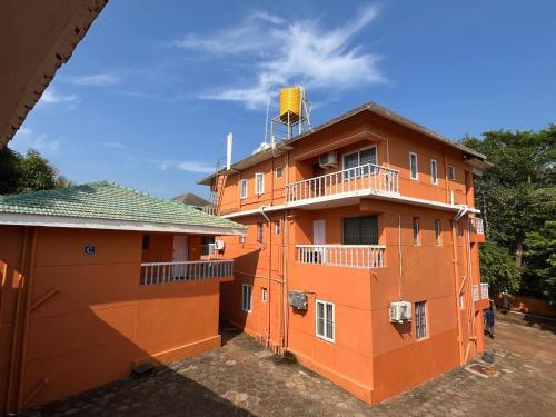 un bâtiment orange avec un balcon au-dessus dans l'établissement Kawari Resort, à Gokarna
