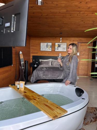 a woman standing in a bath tub in a bedroom at Cabanas nascer do sol - Canyon in Alfredo Wagner