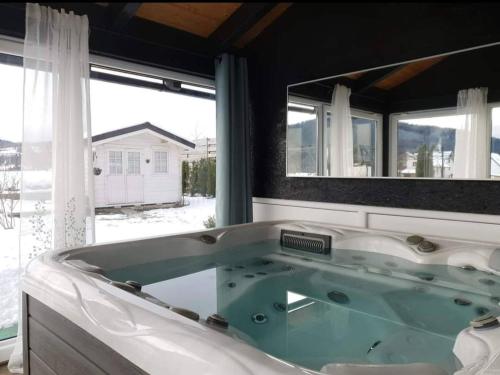 eine große Badewanne in einem Zimmer mit Fenster in der Unterkunft ForRest Spa Apartment - Private Jacuzzi & Sauna in Ravna Gora