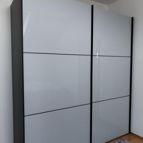 ein Kleiderschrank mit weißen Türen in einem Zimmer in der Unterkunft ForRest Spa Apartment - Private Jacuzzi & Sauna in Ravna Gora