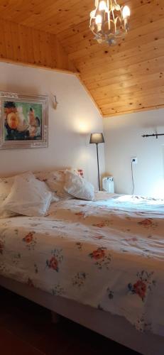 a bedroom with a large bed with a wooden ceiling at Boerderij de Breken in Heerde