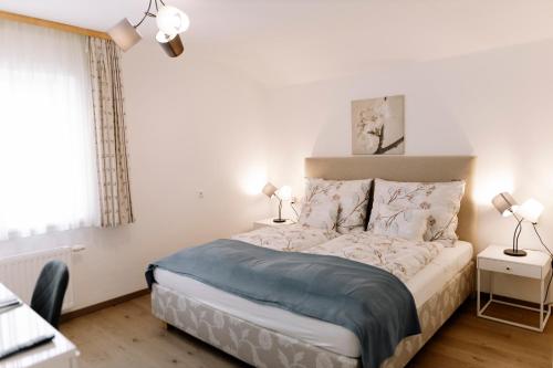 une chambre avec un lit et deux lampes et une fenêtre dans l'établissement Haus Montis, à Haus im Ennstal