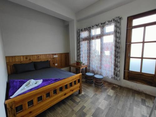 a bedroom with a wooden bed and a window at Chasumi Homestay in Darjeeling