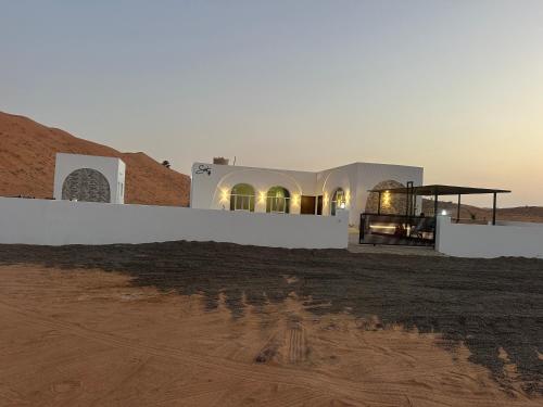 a building in the middle of a desert at Sunset77 in Al Wāşil