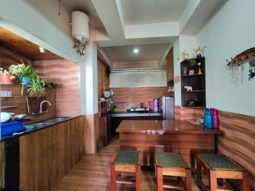 a kitchen with a wooden counter and wooden stools at Chasumi Homestay in Darjeeling