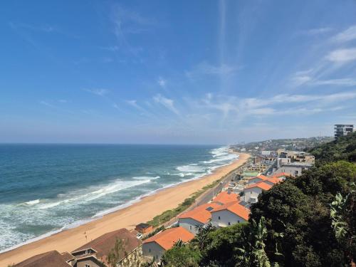 ウムドロティにあるCamarque 101 - 3 Bedroom Apartment - 180 Degree Sea Views In Umdlotiの家屋と海の景色を望む