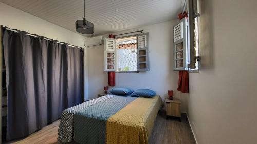 a bedroom with a bed with blue pillows on it at Maison individuelle de plain-pied in Schœlcher