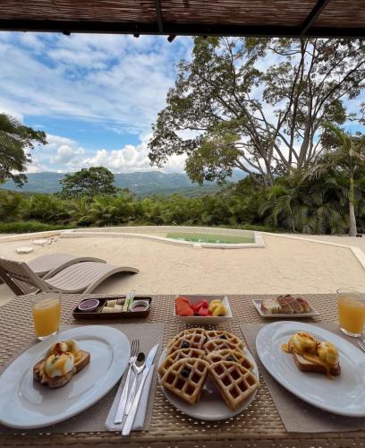 a table with plates of food and waffles on it at IslaVerde Hotel in La Mesa