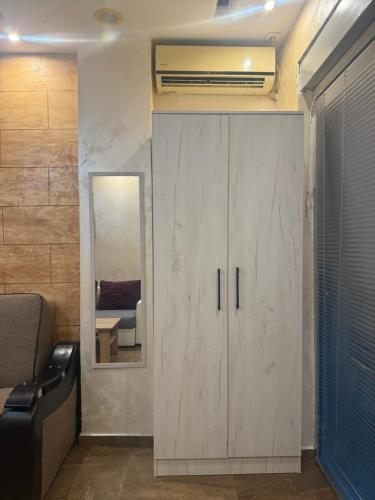 a room with a cabinet with a mirror and a fan at Apartman Martina 3 in Rafailovici