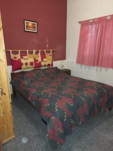 a bedroom with a bed with a red wall at BelloLugar in San Rafael