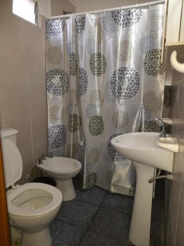 a bathroom with a toilet and a sink and a shower curtain at BelloLugar in San Rafael
