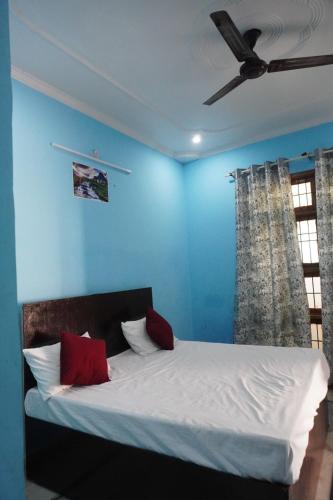 a blue bedroom with a bed with red pillows at Ds Royal Inn in Malhour