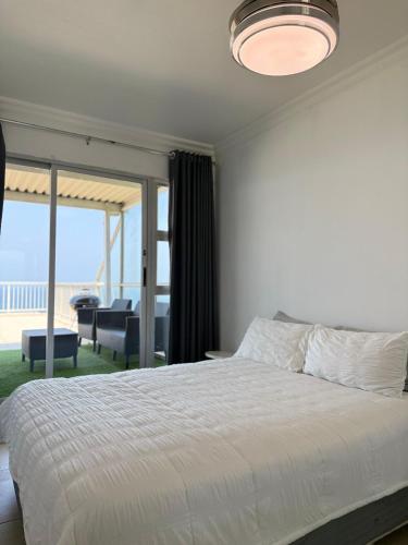a bedroom with a bed and a view of the ocean at 101 Camarque - 3 Bedroom Beachfront Apartment In Umdloti - 180 Degree Sea Views in Umdloti