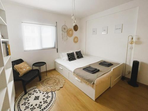 a small bedroom with a bed and a chair at Casa C`Alma - Downtown Olhão Apartment with Pool in Olhão