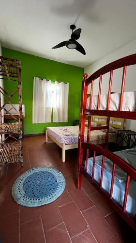 a room with two bunk beds and a ceiling fan at Hostel Beira Mar in Ilha Comprida