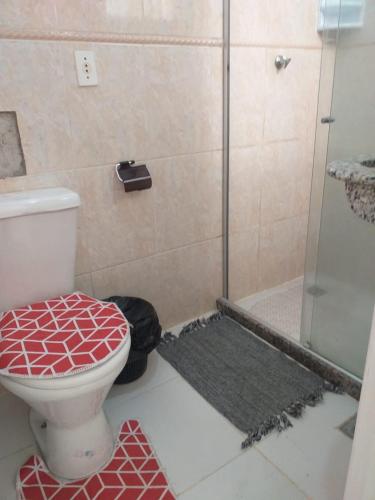 a bathroom with a toilet and a glass shower at Suite Brisa 201 in Pedra de Guaratiba
