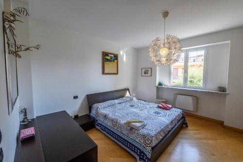 a bedroom with a bed and a table and a chandelier at Appartamento e terrazza vista mare con giardino in Finale Ligure