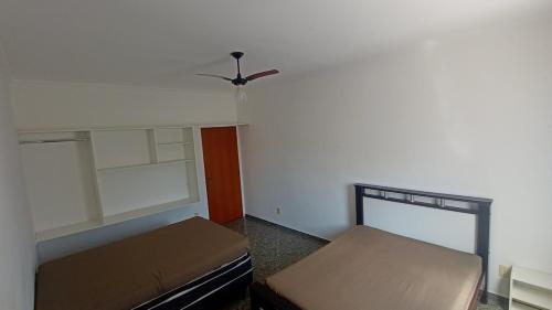 Una habitación con dos camas y un ventilador de techo. en Espaço Recanto do Guerreiro, en Pindamonhangaba