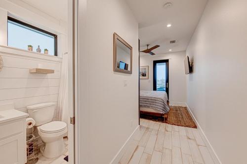 a bathroom with a toilet and a bed in a room at Double Dunes! Heated Pool with Ocean Views! in Port Aransas