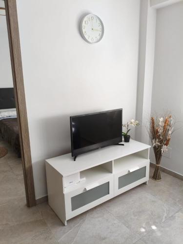 a living room with a tv on a white cabinet at HUELIN PLAYA in Málaga