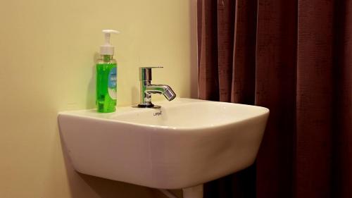 ThandikudiHasvika Hilltop Resort and Hotel的水槽上放着一瓶绿色的肥皂
