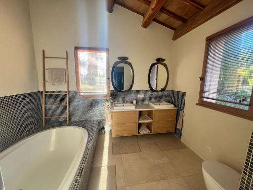 y baño con bañera, 2 lavabos y espejos. en Villa Alta Rocca, en Le Tholonet