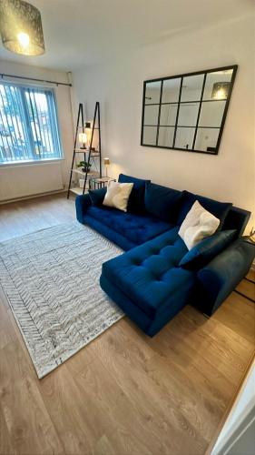 a living room with a blue couch and a rug at Modern House on the Mersey in Wallasey
