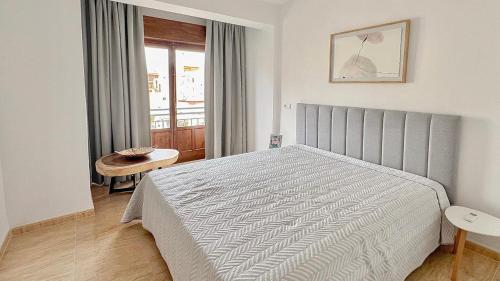 a bedroom with a bed and a table and a window at Sol 3-Bedroom Apartments in Calpe