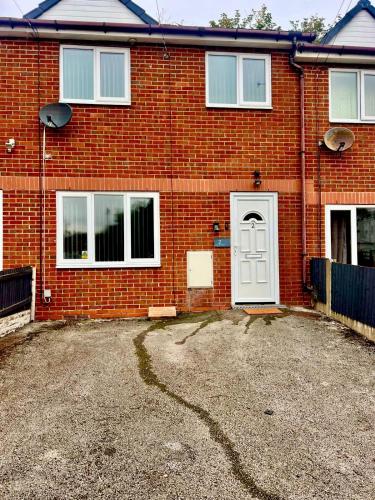 a red brick house with a white door at Modern House on the Mersey in Wallasey