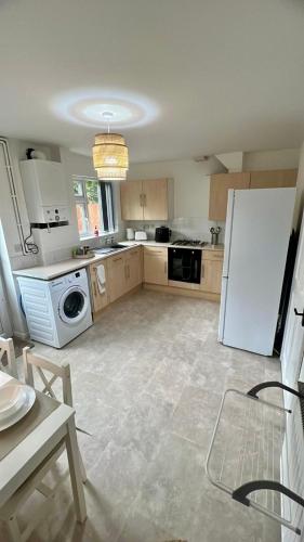 a kitchen with a white refrigerator and a dishwasher at Modern House on the Mersey in Wallasey