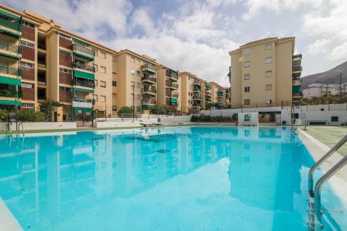 ein großer Pool vor einigen Apartmentgebäuden in der Unterkunft SUN APARTMENT - 3 bedrooms, priv parking, pool, AC, tv channels, fibre net in Los Cristianos
