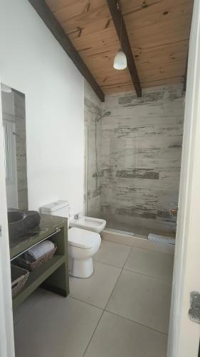 a white bathroom with a toilet and a sink at Morada entre Valles in San Carlos de Bariloche