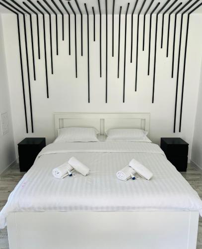 a bedroom with a white bed with black and white stripes at THE W Villa in Topliţa