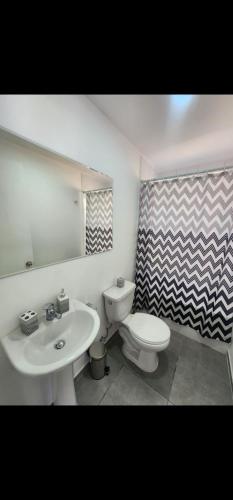 een badkamer met een wastafel, een toilet en een douchegordijn bij Casa nueva amoblada in Ovalle