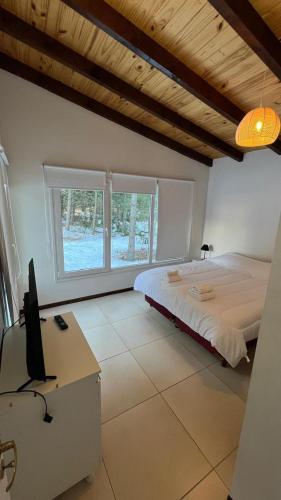 a bedroom with a bed and a desk with a television at Morada entre Valles in San Carlos de Bariloche