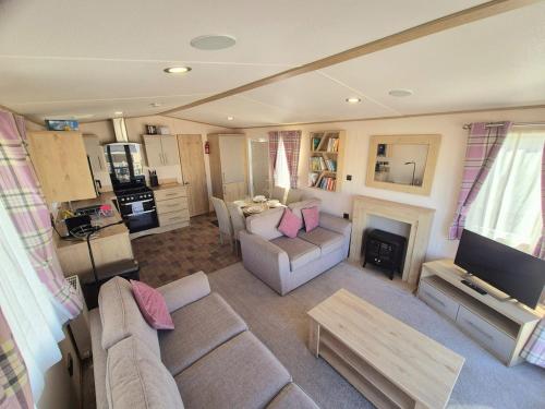 a living room with a couch and a fireplace at ABI Beverley - Dog friendly, Family friendly Whitstable in Seasalter