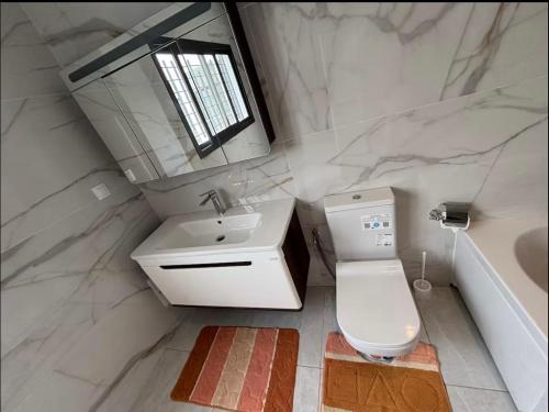 łazienka z umywalką, toaletą i lustrem w obiekcie Maison w mieście Mbour