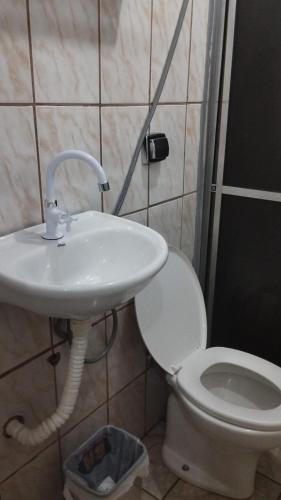 a bathroom with a sink and a toilet at Quarto Conjugado in Itajubá
