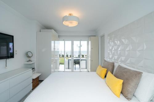 a bedroom with a bed with yellow pillows at Beachfront Haven in Mijas Costa