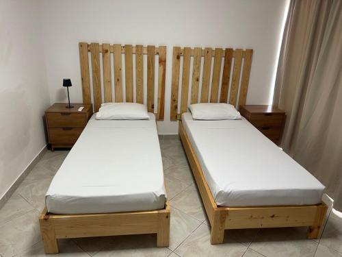 two twin beds in a room with wooden headboards at Casa Morabeza in Santa Maria