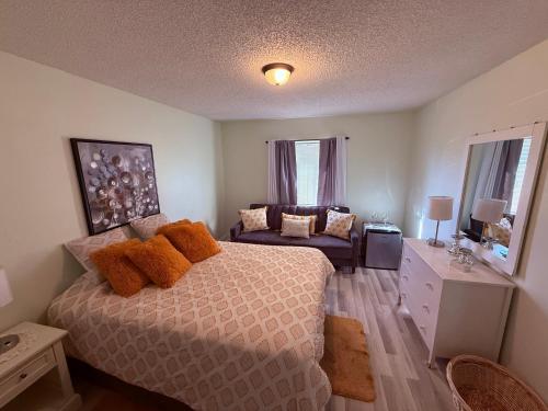 a bedroom with a bed and a couch in it at Habitacion Privada a 15 minutos de Walt Disney World in Kissimmee