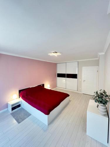 a large bedroom with a red bed and white floors at Central Home with Underground Parking in Varna City